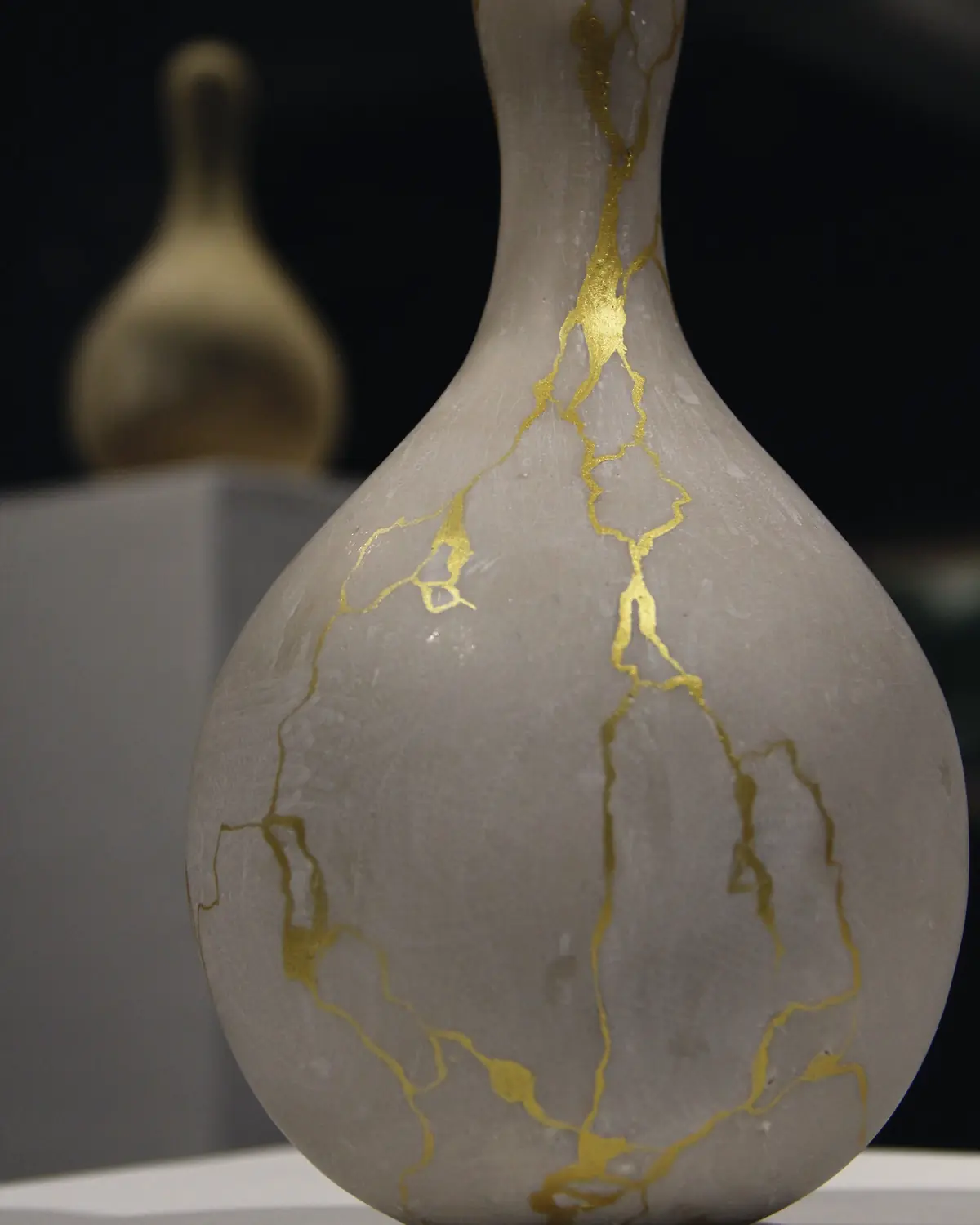 A gray ceramic vase with its cracks repaired in gold